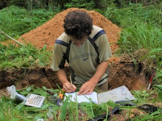 Описание почвенного разреза. Почвовед вносит пометки в полевой дневник. Автор фото: Е.В. Тихонова